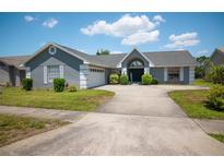 Charming home featuring manicured landscaping, a curved driveway, and a welcoming front entrance at 8712 Ashbury Dr, Hudson, FL 34667