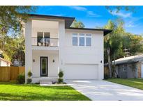 Modern two-story home featuring a balcony, manicured lawn, and a two-car garage at 116 W Stanley St, Tampa, FL 33604
