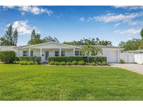 Charming single-story home with lush green lawn, manicured hedges, and a well-maintained front yard at 1404 84Th N Ave, St Petersburg, FL 33702