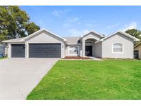 Charming single Gathering home with a manicured lawn and a spacious three car garage at 2203 Malaga Ave, Spring Hill, FL 34609