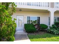 Inviting condo exterior featuring a well-manicured lawn and a bright, white front door and windows at 2284 Philippine Dr # 7, Clearwater, FL 33763