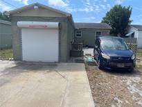 Exterior view of garage with an Overhead Door and a blue van parked alongside the driveway at 2435 37Th N Ave, St Petersburg, FL 33713