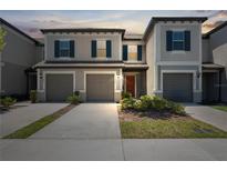 Charming two-story townhome with gray stucco, shutters, and attached garages at 31970 Blue Passing Loop, Wesley Chapel, FL 33545