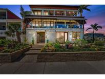 Stunning three-story home with lush landscaping, gated entry, and inviting outdoor living spaces at 5659-5657 Shore S Blvd, Gulfport, FL 33707