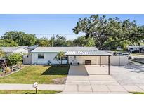 Charming single-story home featuring a carport, well-maintained lawn, and mature landscaping at 6894 82Nd N Ave, Pinellas Park, FL 33781