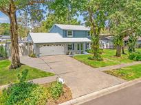 Charming two-story home with a two-car garage and a lush green lawn at 9410 Alanbrooke St, Temple Terrace, FL 33637