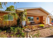Charming single-story home with an inviting front porch and colorful landscaping at 9469 Treasure Ne Ln, St Petersburg, FL 33702