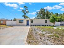 Inviting single-story home featuring a blue front door, a concrete driveway, and a well-maintained front yard at 1235 Stockton Dr, Clearwater, FL 33755