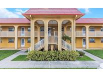 Charming condo building with colorful red roof, balconies, and well-maintained landscaping at 1301 S Hercules Ave # 19, Clearwater, FL 33764