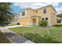 Inviting two-story home with a well-manicured lawn and attached two-car garage at 13506 Copper Belly Ct, Riverview, FL 33569