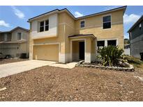 Two story home featuring a two car garage, neutral paint scheme and manicured landscaping at 13506 Copper Belly Ct, Riverview, FL 33569