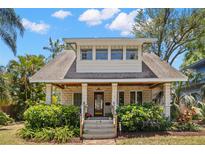 Charming two-story home featuring a stone facade, covered front porch, and well-manicured landscaping at 146 8Th Ne Ave, St Petersburg, FL 33701