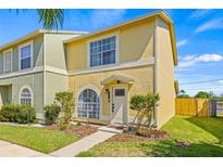 Charming home featuring a well-maintained lawn, arched window, and inviting front entrance at 1577 Chateaux De Ville Ct, Clearwater, FL 33764