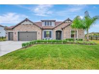Charming single-story home features a stone facade, well-manicured lawn, and a two-car garage at 17804 Brewster Grn, Lutz, FL 33559