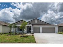 Charming one-story home featuring a well-manicured lawn, two car garage and a welcoming entrance at 190 Rain Berry Ave, Ruskin, FL 33570
