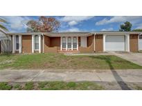 Inviting single-story home with a two-car garage and well-maintained front yard at 2105 Sugarbush Dr, Holiday, FL 34690