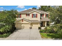 Charming two-story home featuring a spacious three car garage, manicured landscaping, and inviting curb appeal at 2387 Bartolo Dr, Land O Lakes, FL 34639