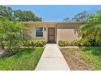 Charming single-story home with a well-maintained lawn and lush tropical landscaping at 2640 Woodgate Ln # F6, Sarasota, FL 34231