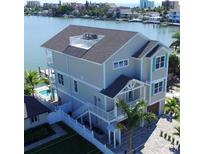 Stunning waterfront home with multiple levels, rooftop deck, and a pool, showcasing luxurious coastal living at 305 Harbor Dr, Indian Rocks Beach, FL 33785