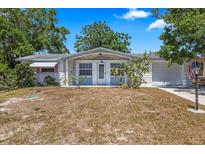 Charming single-story home with an attached garage, tidy landscaping, and a well-manicured lawn at 4017 Moog Rd, Holiday, FL 34691