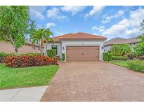 Charming single-story home featuring a tile roof, brick driveway, and manicured landscaping at 4610 Alexandria Ct, Palmetto, FL 34221