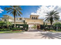 Community entrance with lush landscaping, palm trees and inviting architecture under a bright blue sky at 501 Knights Run Ave # 1335, Tampa, FL 33602