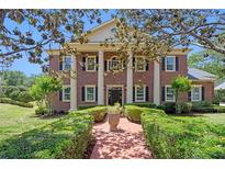Stunning brick home with stately columns, manicured lawn, and charming front walkway at 5017 Muir Way, Lithia, FL 33547