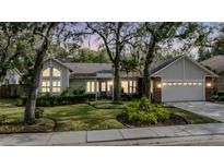 Charming single-story home boasts a well-manicured lawn and mature trees with lush landscaping around the property at 614 Fayette S Dr, Safety Harbor, FL 34695