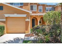 Charming two-story home featuring a one-car garage and an inviting arched entryway at 11611 Mango Ridge Blvd, Seffner, FL 33584