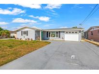 Charming single-story home with gray exterior, well-maintained lawn, and a long driveway at 12700 5Th Isle, Hudson, FL 34667