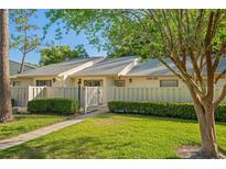 Charming condo with a well-manicured lawn, inviting walkway, and decorative fence at 1300 Shady Pine Way # B, Tarpon Springs, FL 34688