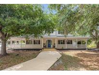 Charming two-story home featuring a spacious porch, well-maintained yard, and a welcoming blue front door at 1350 Mustang St, Nokomis, FL 34275