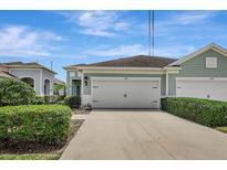 Charming home showcasing a well-manicured lawn, lush greenery, and a two-car garage at 13518 Circa Crossing Dr, Lithia, FL 33547