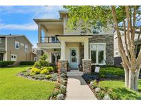 Charming home featuring a stone facade, manicured landscaping, and a welcoming light blue front door at 14204 Barrington Stowers Dr, Lithia, FL 33547