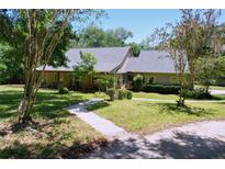 Charming single-story home with a well-manicured front yard and a welcoming pathway at 16224 Iola Woods Trl, Dade City, FL 33523