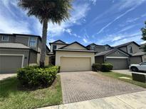 Charming home featuring a two-car garage, brick paver driveway, and lush landscaping at 2731 Hampton Green Ln, Brandon, FL 33511