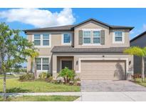 Charming two-story home with well-manicured lawn and an attached two-car garage at 3113 Marine Grass Dr, Wimauma, FL 33598