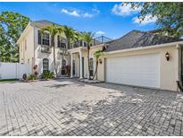 Elegant two-story home with palm trees, beautiful landscaping and a brick driveway at 3117 W Knights Ave, Tampa, FL 33611