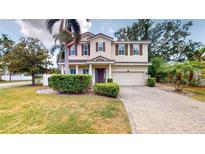 Inviting two-story home with a well-manicured lawn, mature landscaping, and a paver driveway at 3615 S Church Ave, Tampa, FL 33629