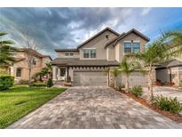 Stunning two-story home with a paver driveway and three-car garage, perfect for Gathering living at 4689 Wandering Way, Wesley Chapel, FL 33544