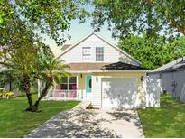 Charming two-story home featuring a well-manicured lawn and a lovely front porch at 5607 Tanagergrove Way, Lithia, FL 33547