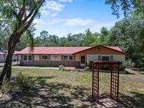 Charming single story home with a red roof and manicured front lawn at 7095 South St, Webster, FL 33597