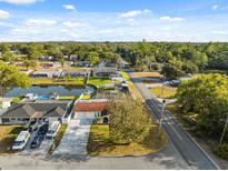 Birds eye view of a suburban neighborhood with lush greenery, waterfront properties, and well-maintained streets at 7325 Calder Dr, New Port Richey, FL 34653