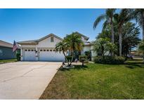 Charming single-story home with a well-manicured lawn, palm trees, and a two-car garage at 8926 Garner Ct, Trinity, FL 34655