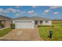 Charming home featuring a well-manicured lawn, two-car garage, and inviting landscaping at 11311 Corey Pavin Ln, San Antonio, FL 33576