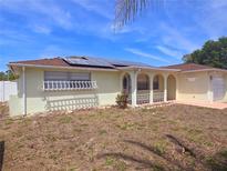 Charming single-story home with a well-maintained lawn, solar panels, and an attached garage at 11625 Constance Dr, Port Richey, FL 34668