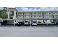 Exterior view of condo complex showing covered parking at 1375 Doolittle Ln # 101, Dunedin, FL 34698