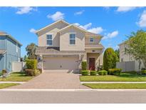 Inviting two-story home with a well-manicured lawn and a brick-paved driveway at 19487 Roseate Dr, Lutz, FL 33558