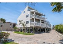 Stunning three-story beach house with elevated construction, multiple decks, and ample parking at 19727 Gulf Blvd # 210, Indian Shores, FL 33785