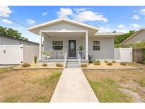 Charming single-story home with a covered front porch, neat landscaping, and a walkway leading to the entrance at 212 N Bradford Ave, Tampa, FL 33609